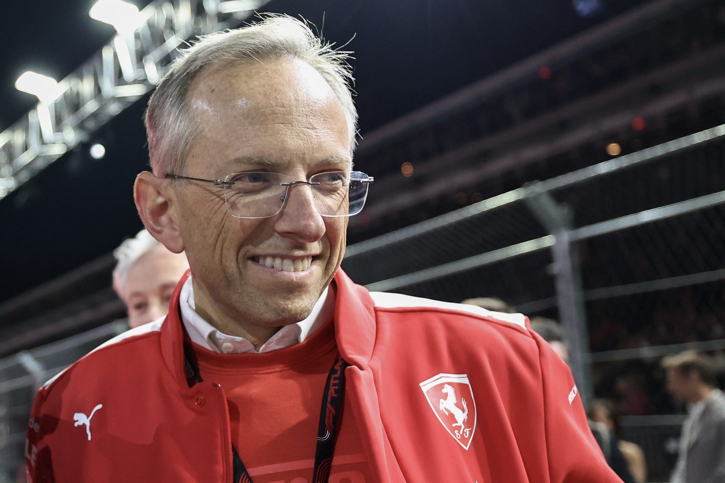 CEO Benedetto Vigna is wearing a red and white Ferrari jacket and standing trackside at the 2023 Las Vegas Grand Prix.
