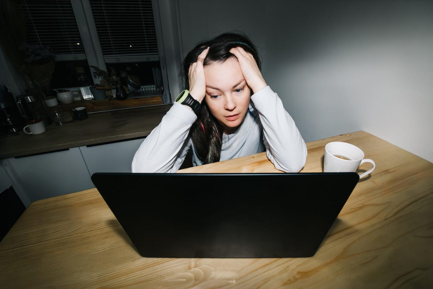woman sitting on a table with a laptop and a mug