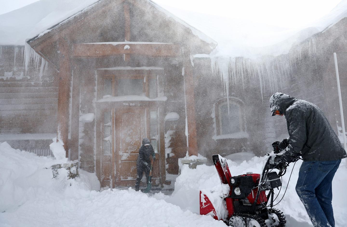 Man operating a snowblower in a blizzard