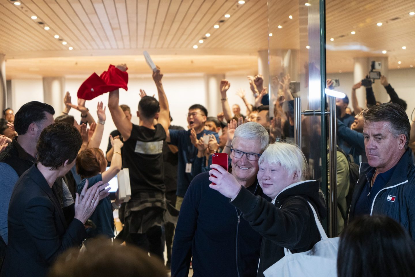 Tim Cook, chief executive officer of Apple Inc., center left, poses for a selfie photograph with a customer during the opening of the new Apple Inc. Jingan store in Shanghai, China, on Thursday, March 21, 2024.