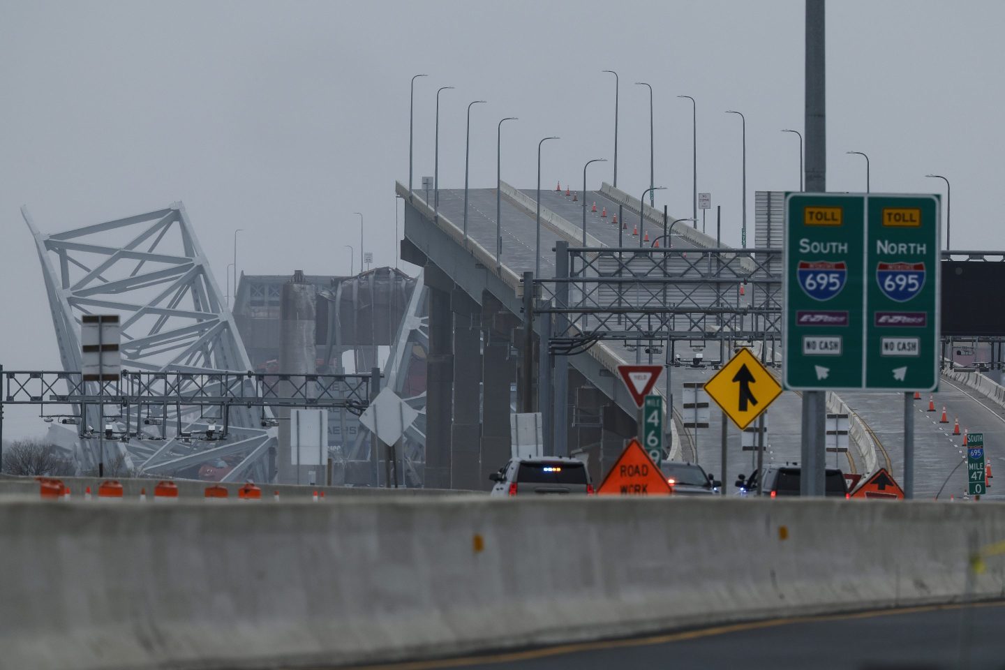 The collapsed Francis Scott Key Bridge is seen in the background of the on ramp to the bridge