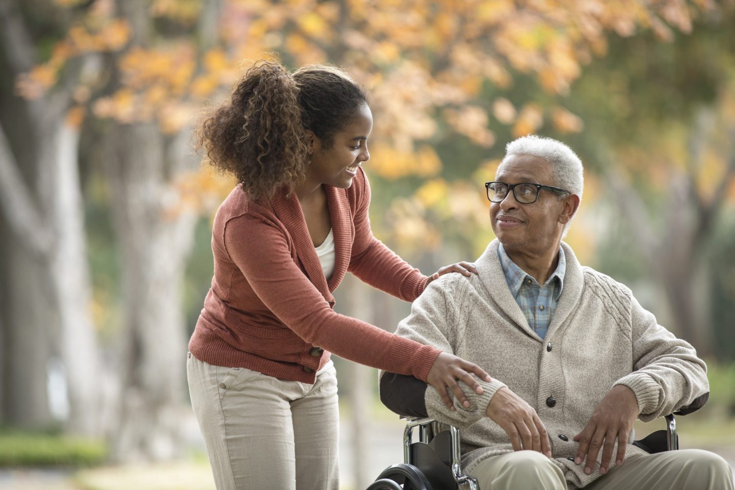 Woman assisting an older man in a wheelchair