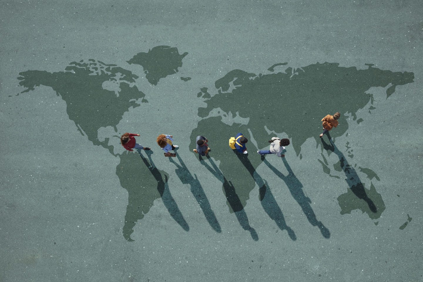 Workers walk across map of the world.