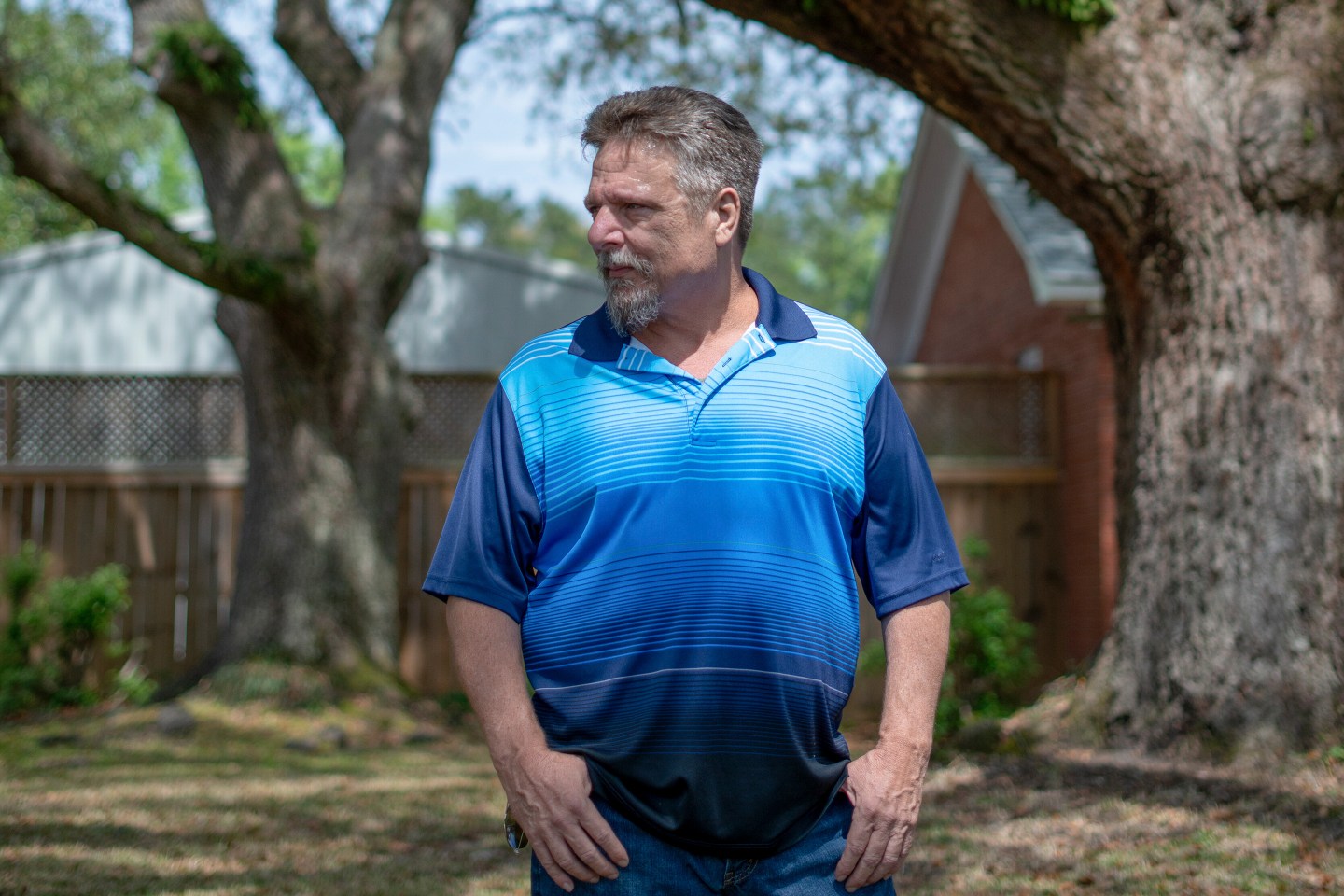 Photo of John Barnett standing outside his home