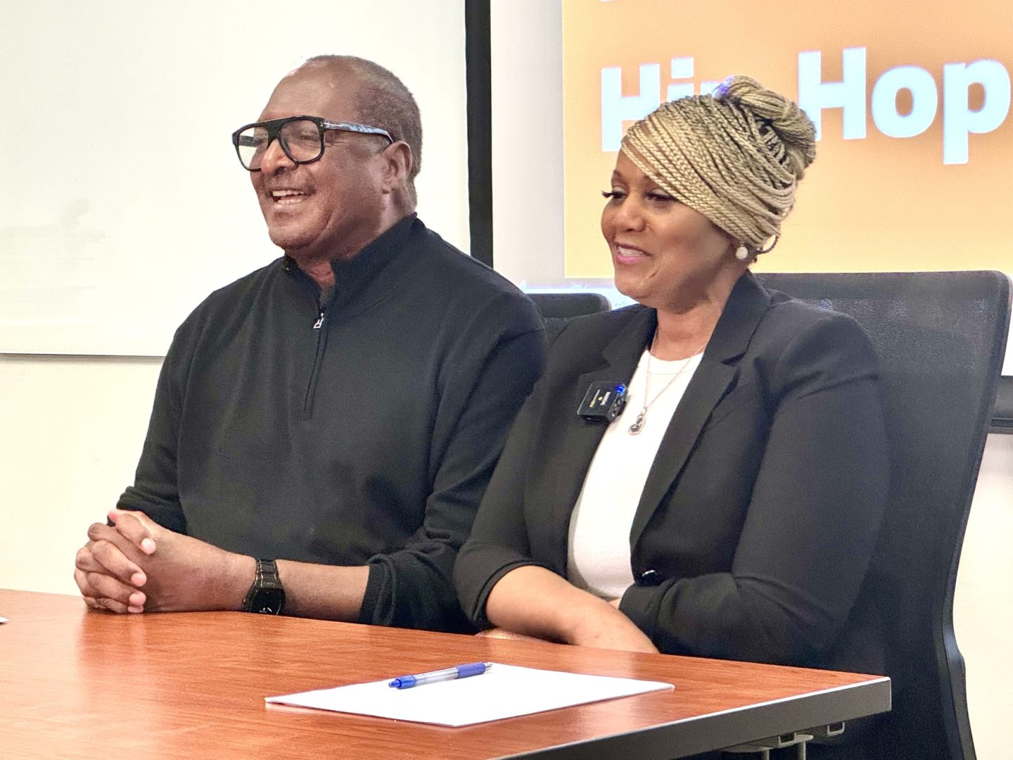 Mathew Knowles and Joi Carr sit at a table smiling during their class.