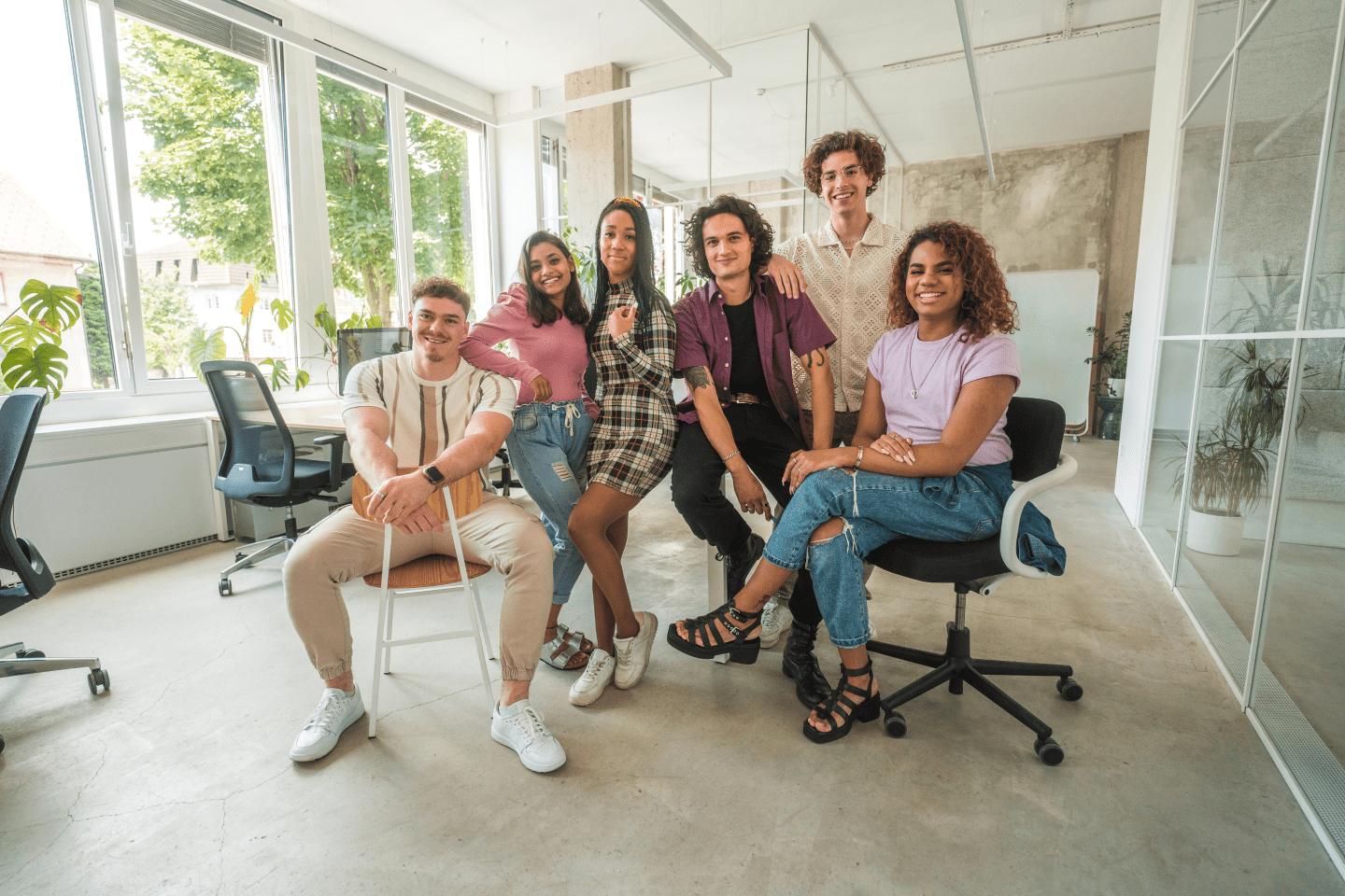Group of Gen Z professionals seated and posed in office.