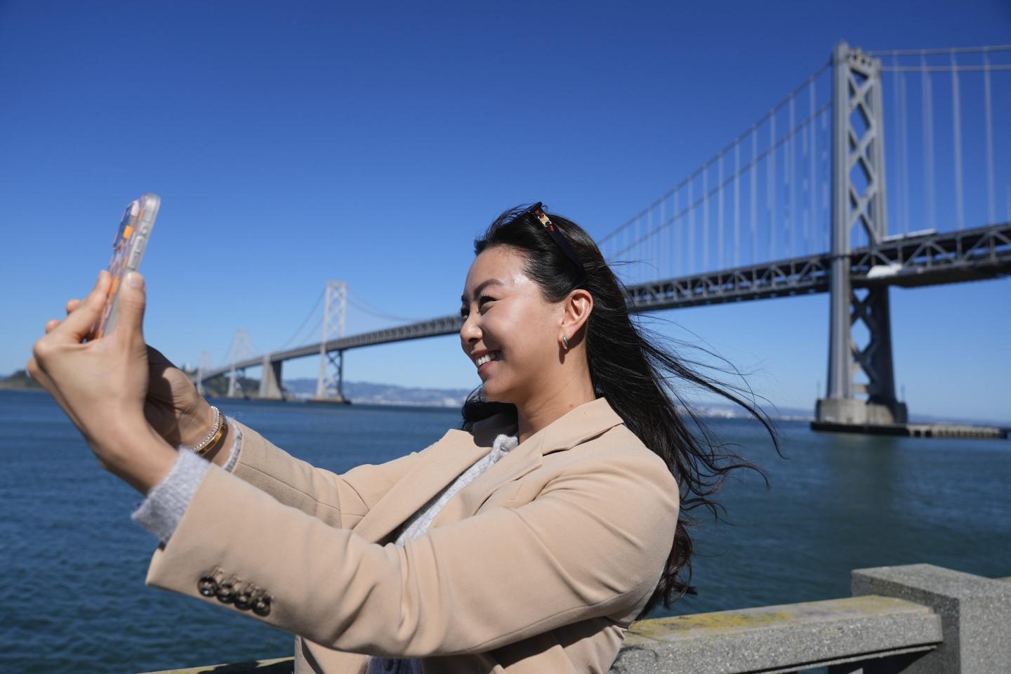 Content creator Cynthia Huang Wang works below the San Francisco-Oakland Bay Bridge in San Francisco, on April 8, 2024.