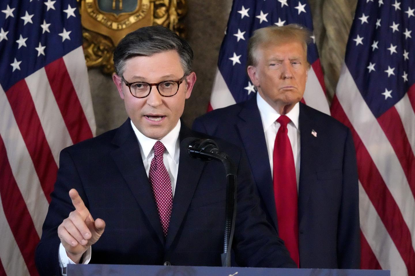 Mike Johnson stands next to Donald Trump