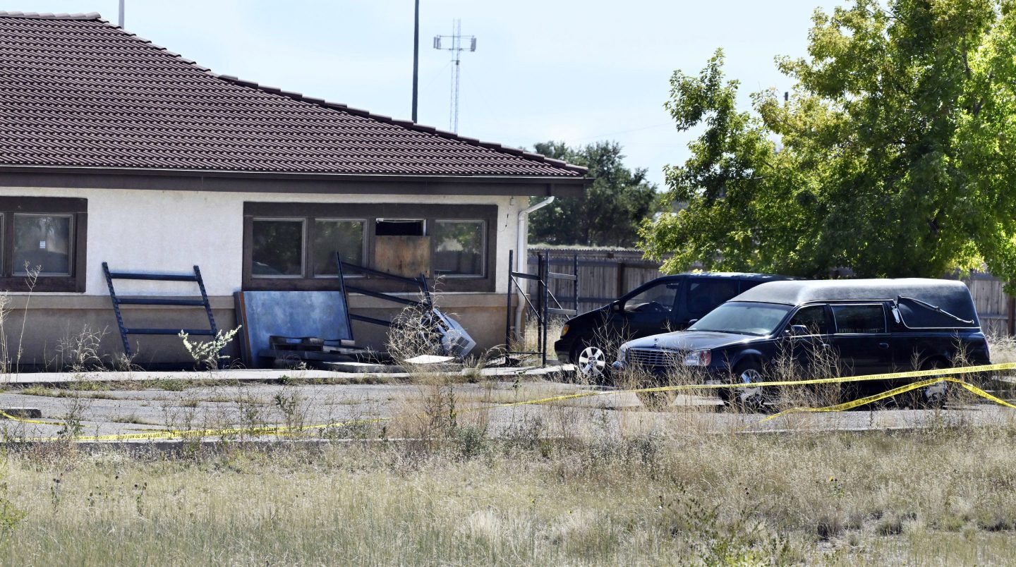 A hearse and debris can be seen at the rear of the Return to Nature Funeral Home, Oct. 5, 2023, in Penrose, Colo.