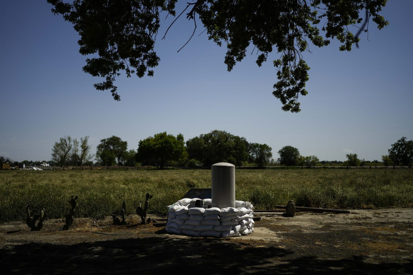 Sandbags are stacked around a well in anticipation of flooding of the Kings River in the Island District of Lemoore, Calif., April 19, 2023.
