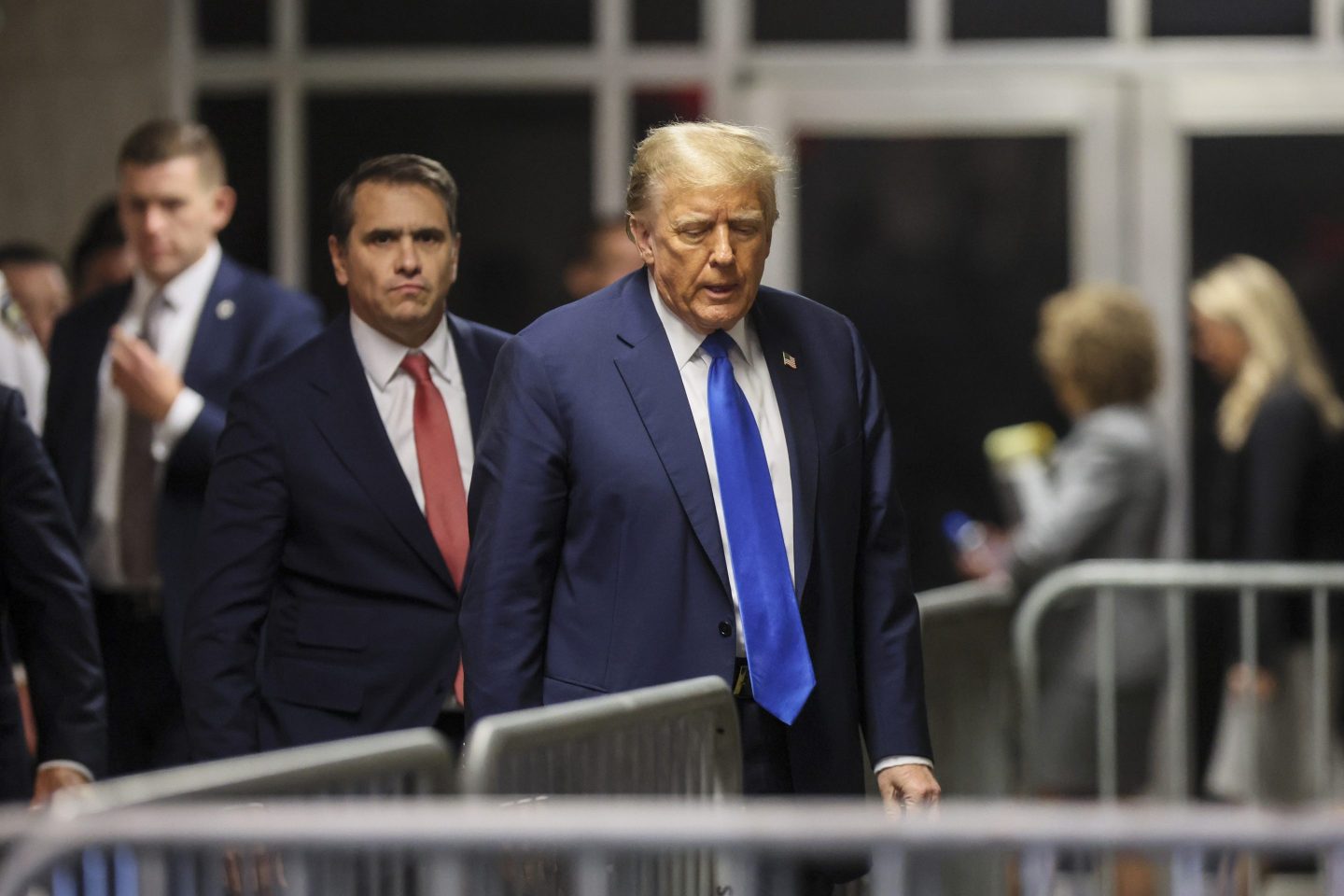 Former President Donald Trump, center, walks through the courthouse, as his attorney, Todd Blanche, left, looks on, on the first day of his criminal trial over charges that he falsified business records to conceal money paid to silence porn star Stormy Daniels in 2016, at Manhattan state court in New York, on April 22, 2024.
