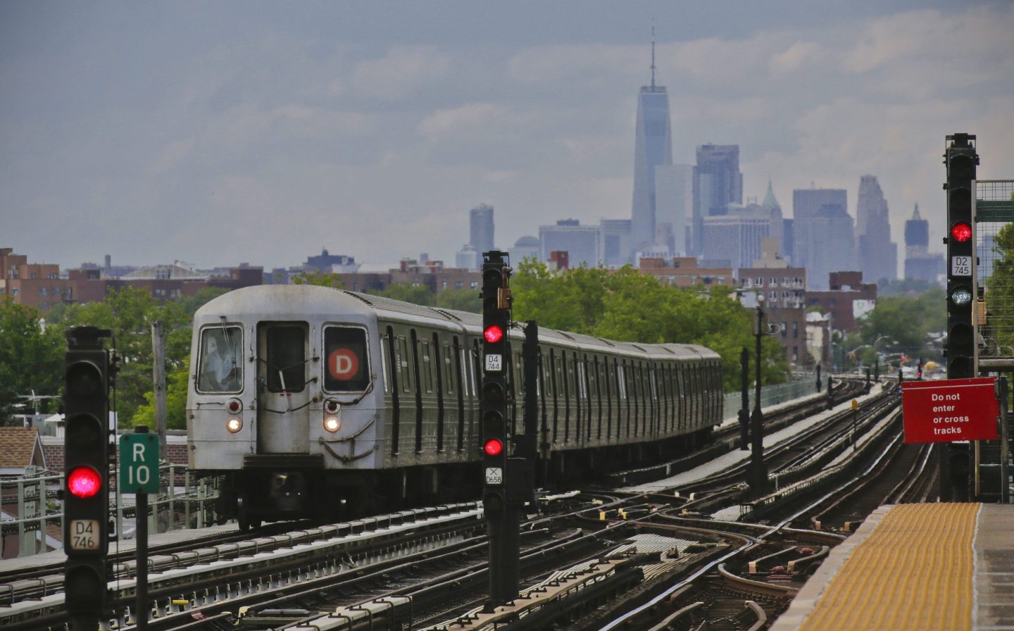 A subway approaches an above ground station in the Brooklyn borough of New York with the New York City skyline in the background, June 21, 2017.