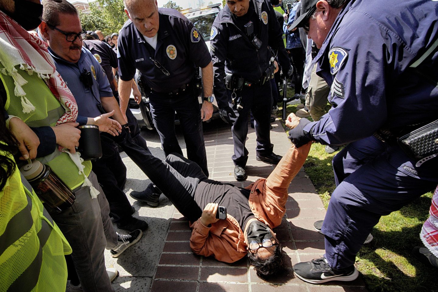 A University of Southern California protester is detained by USC Department of Public Safety officers during a pro-Palestinian occupation at the campus' Alumni Park on Wednesday, April 24, 2024 in Los Angeles.