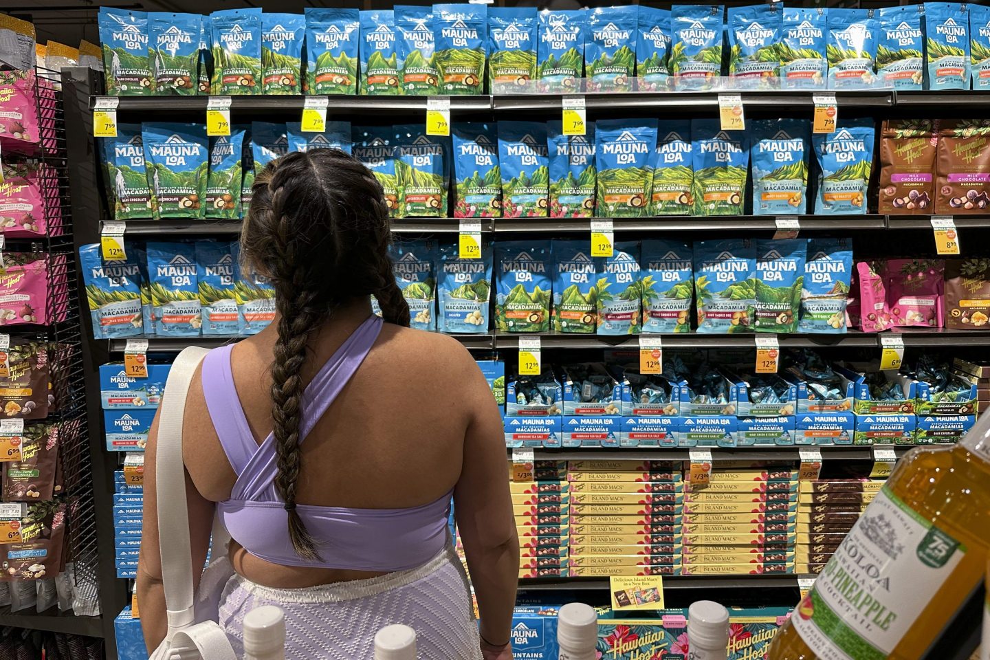 A shopper looks at packages of macadamia nuts at a store on April 26, 2024, in Honolulu.