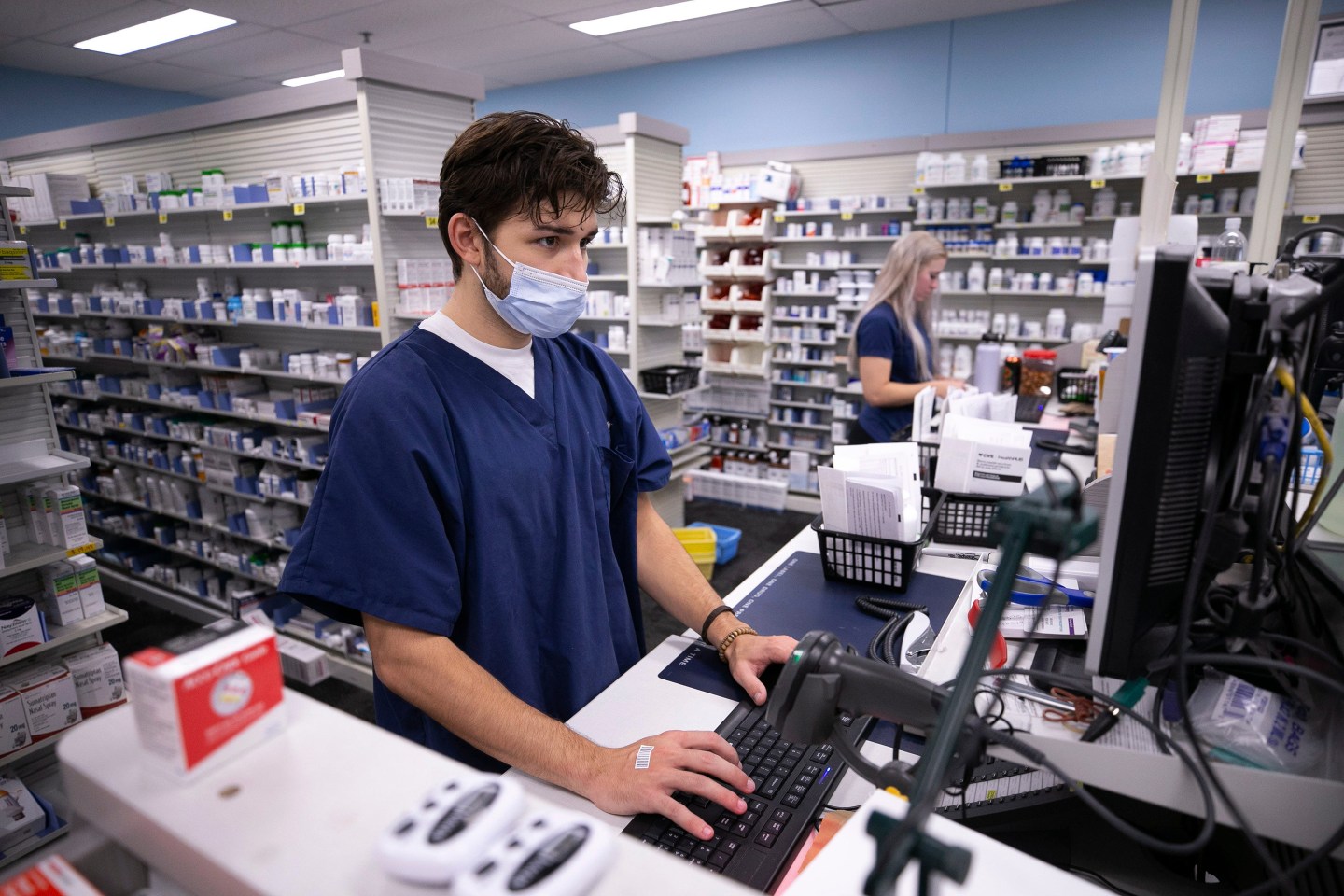 Pharmacy technician Keenan Becker fills prescriptions at a CVS.