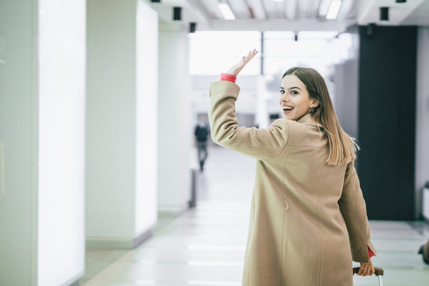 Woman looking over her shoulder to wave goodbye