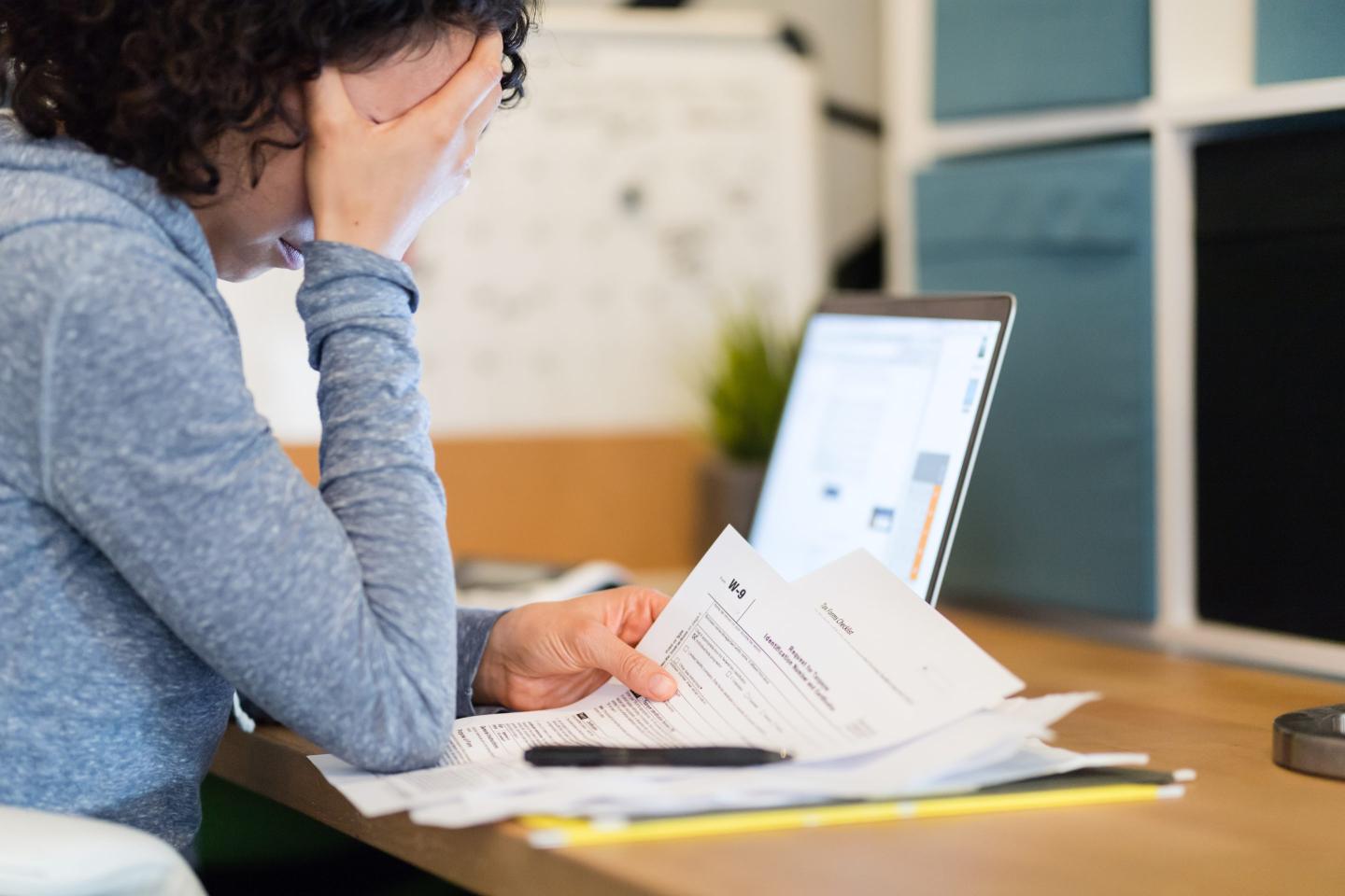 Photo of woman at a desk late at night working on her taxes.