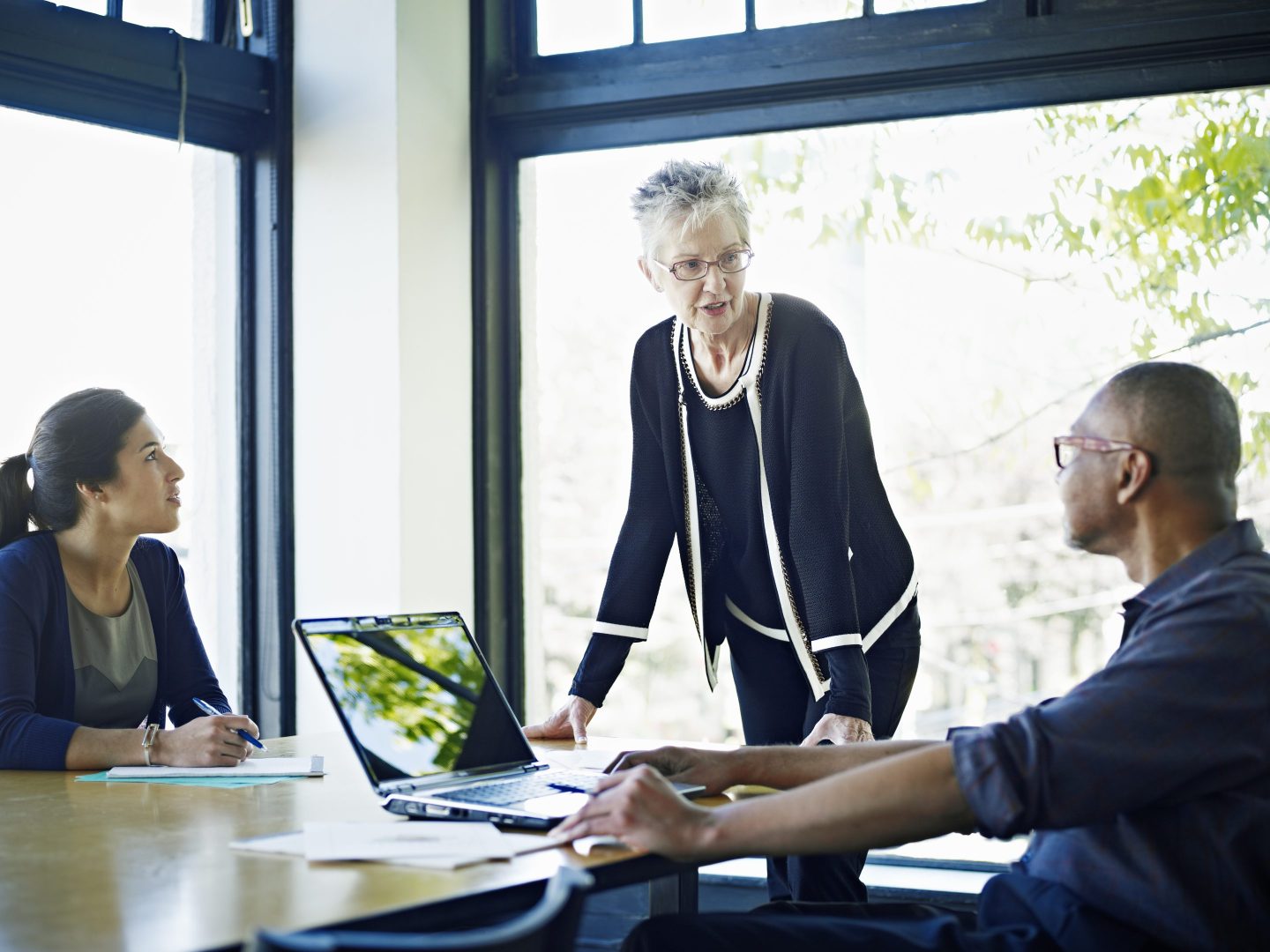 Coworkers in discussion at conference table in office