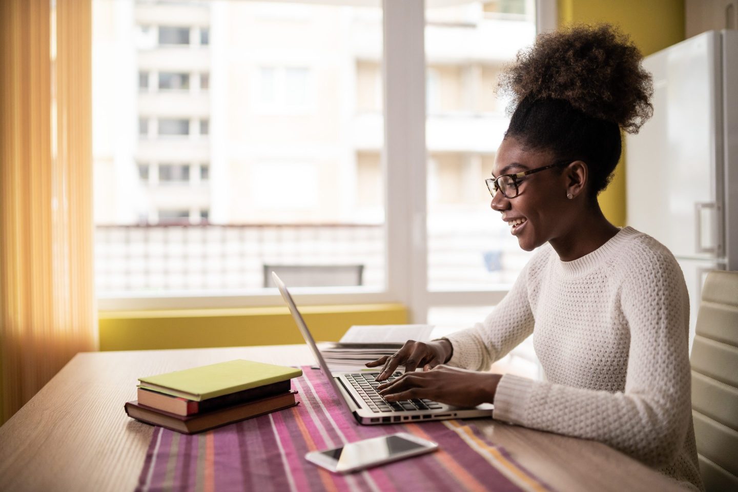 Woman sits at desk looking at computer.