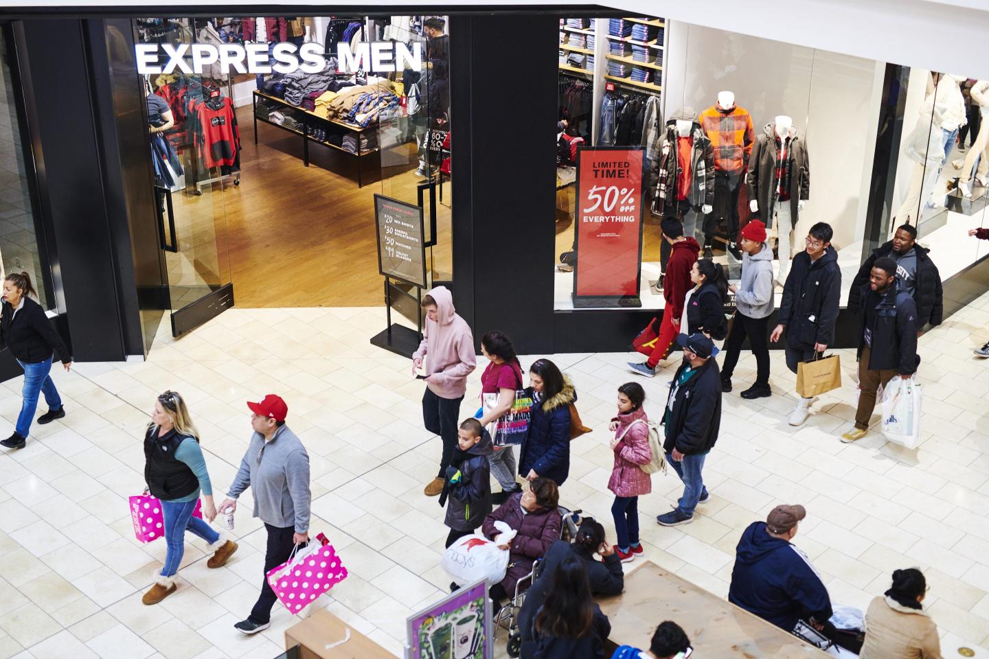 Crowds walk by Express in a mall
