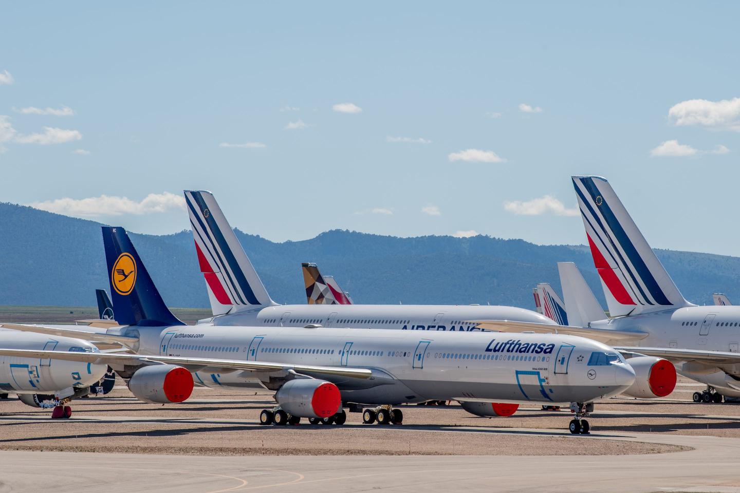 An Airbus A340 passenger aircraft operated by Lufthansa stand next to Air France aircraft parked in a storage facility
