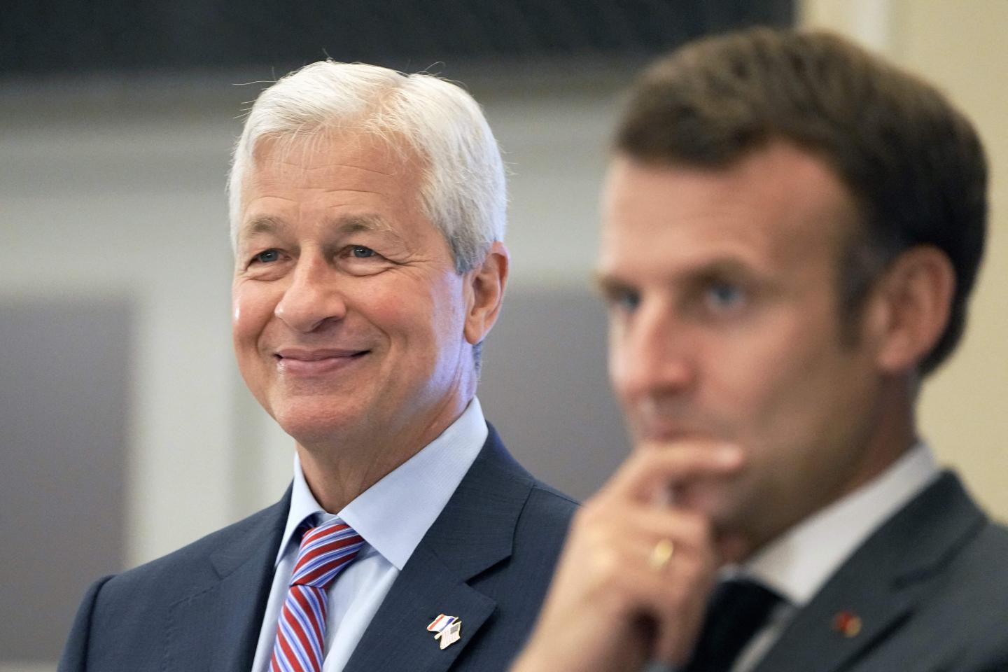 French President Emmanuel Macron (R) and JP Morgan CEO Jamie Dimon (L) react during the inauguration of the new French headquarters of US' JP Morgan bank on June 29, 2021 in Paris.
