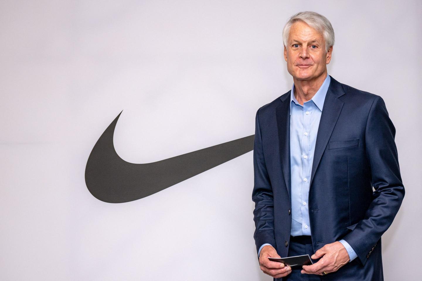 John Donahoe stands next to Nike logo