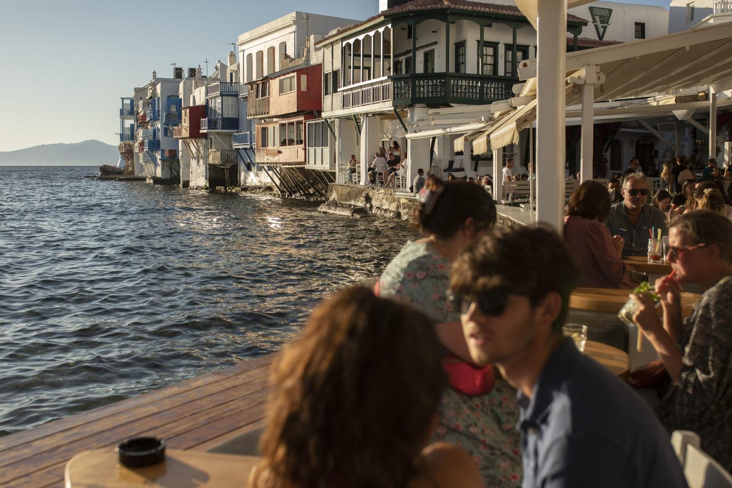 Tourists sitting in a café-bar in Little Venice in the main town of Mykonos.