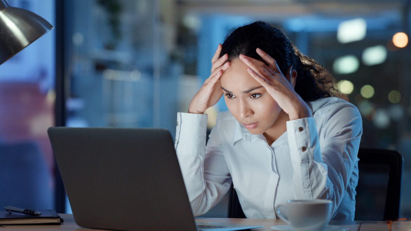A frustrated woman looks at her laptop screen