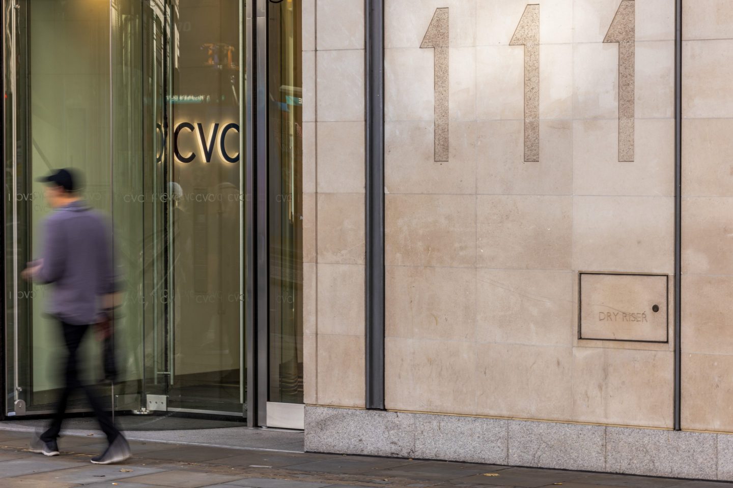 person walking in front of cvc capital's office door