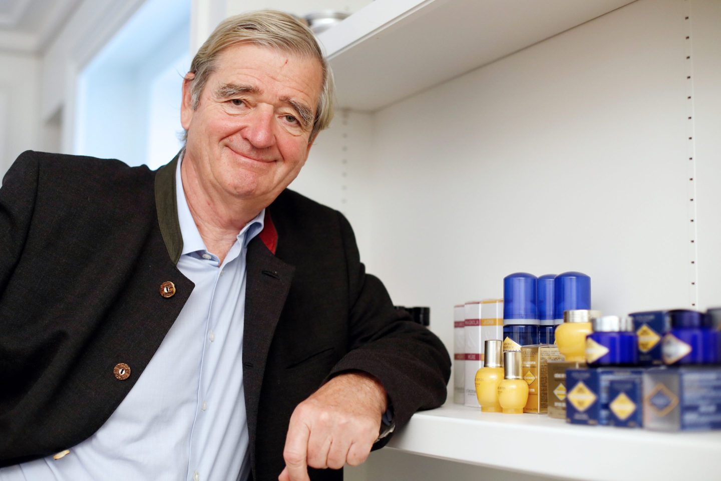Reinold Geiger leans on shelf with cosmetics