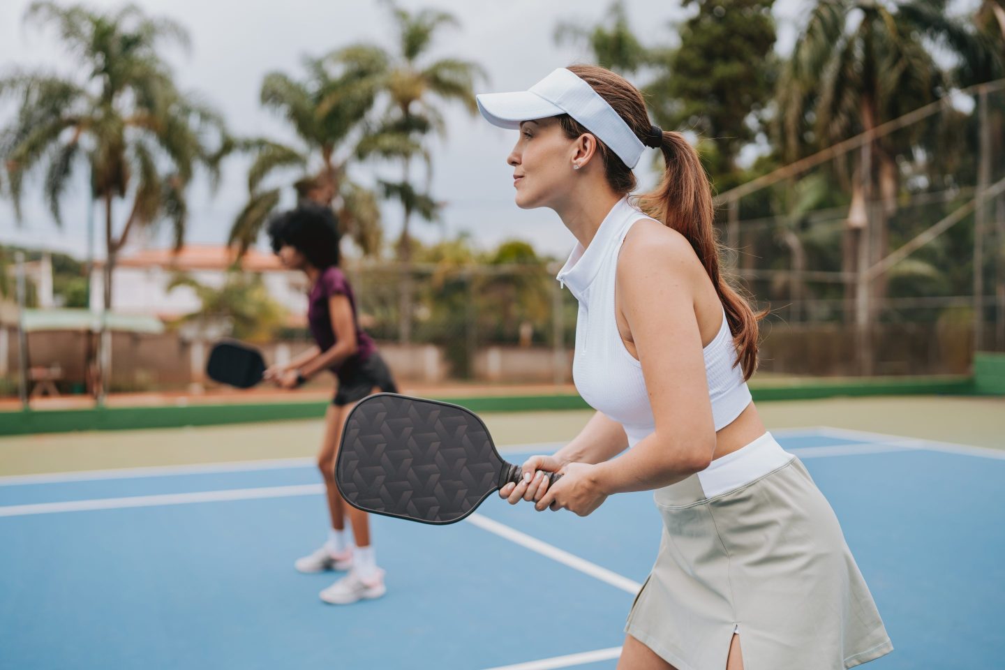 A woman plays pickleball.