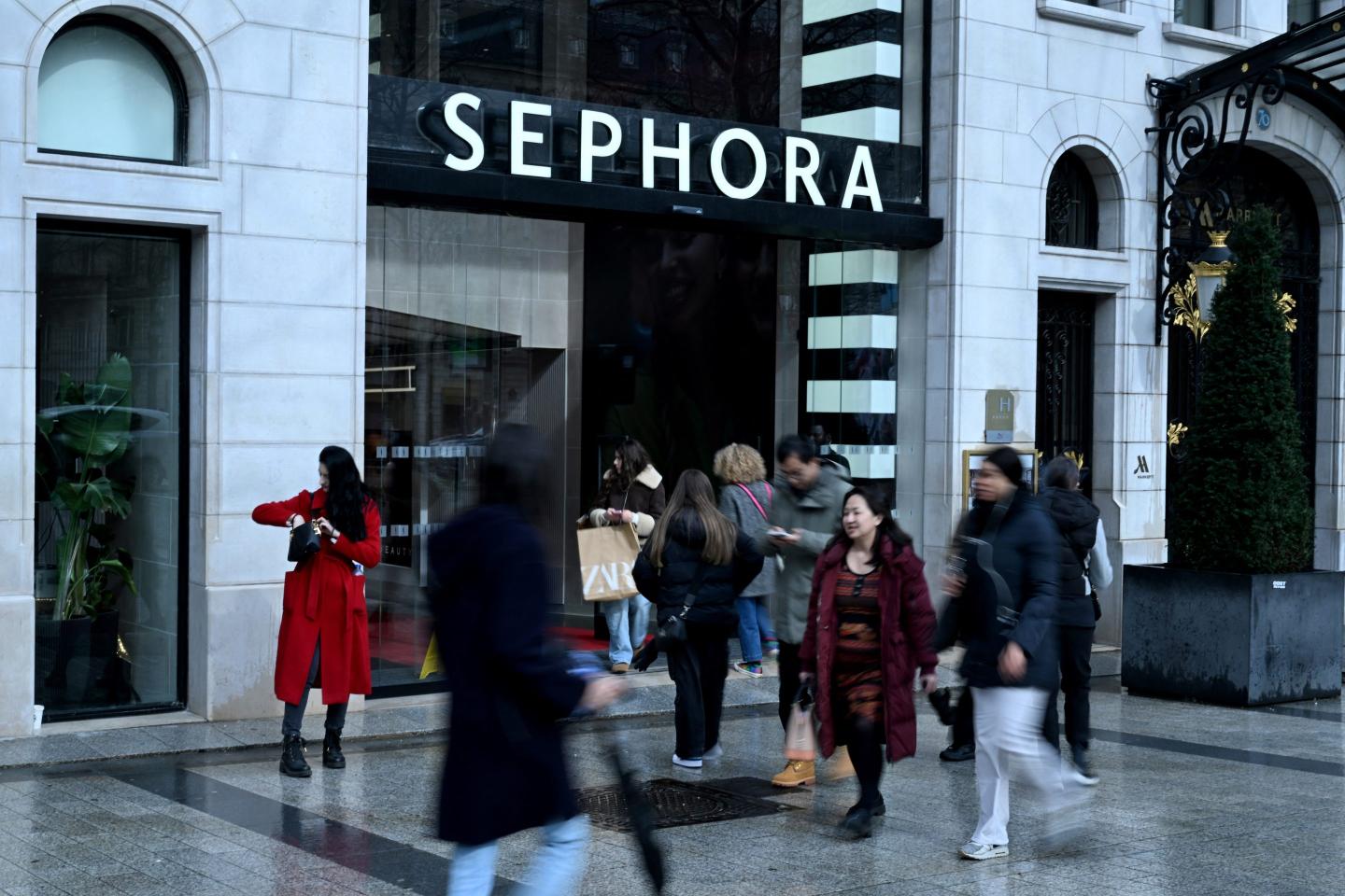 people walking on a busy street outside a Sephora store