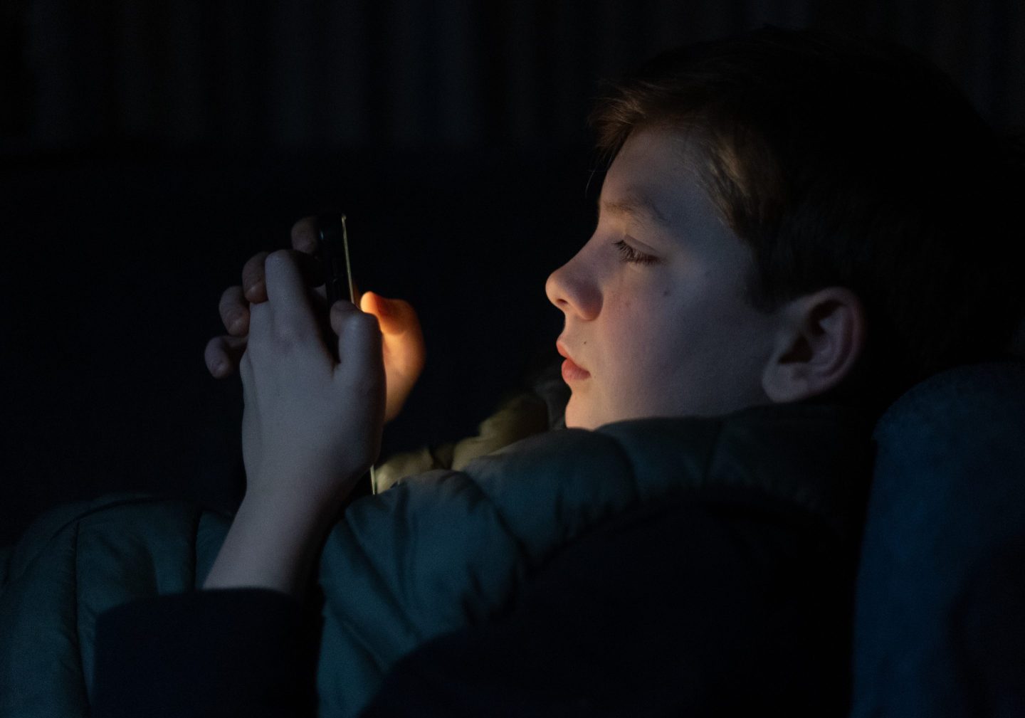 A 12-year-old boy looks at a smartphone screen on March 10, 2024 in Bath, England.