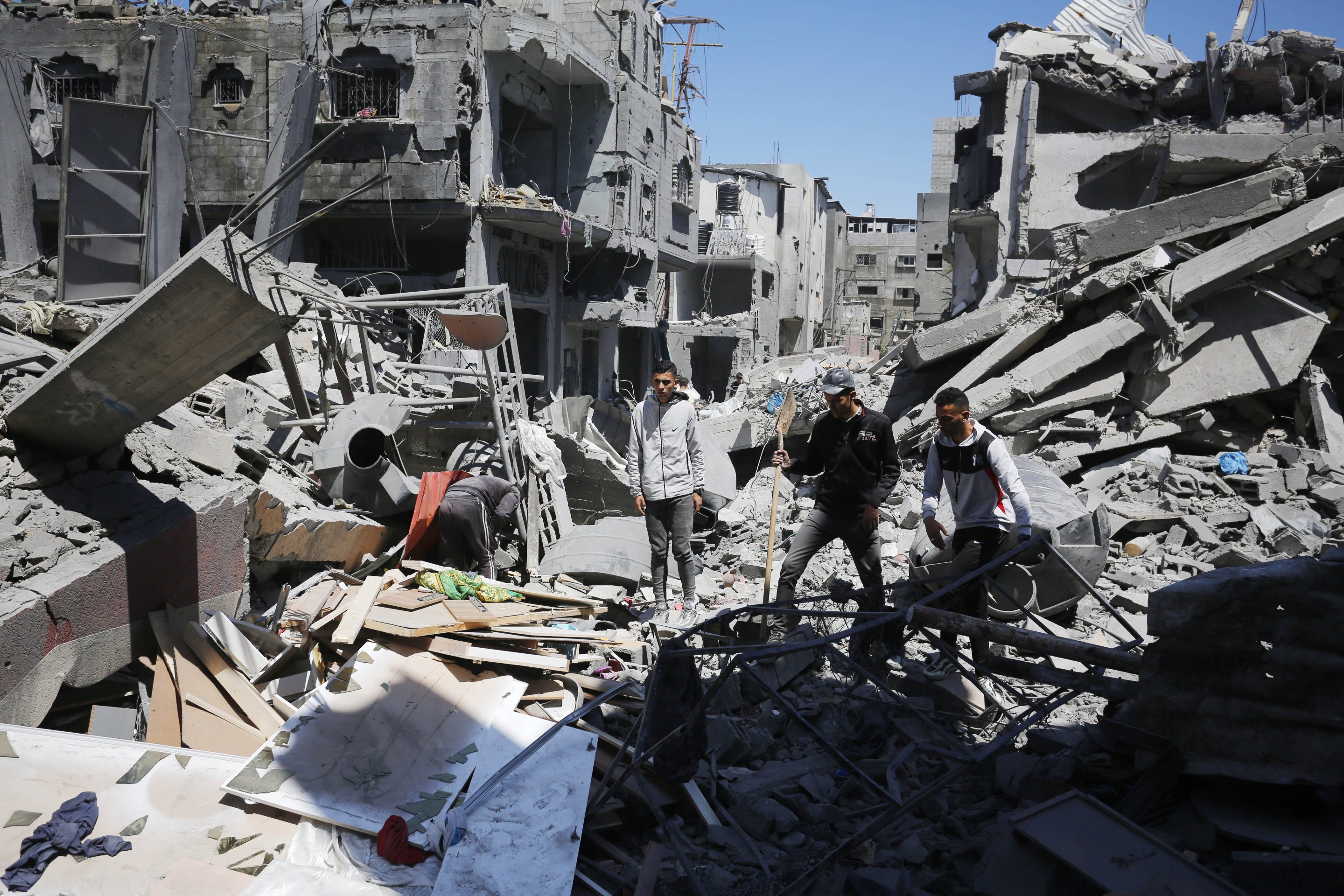 Palestinians living in al-Maghazi Refugee Camp collect the usable items among the rubble of the destroyed buildings following an Israeli attack in Deir al-Balah, Gaza on April 4, 2024.