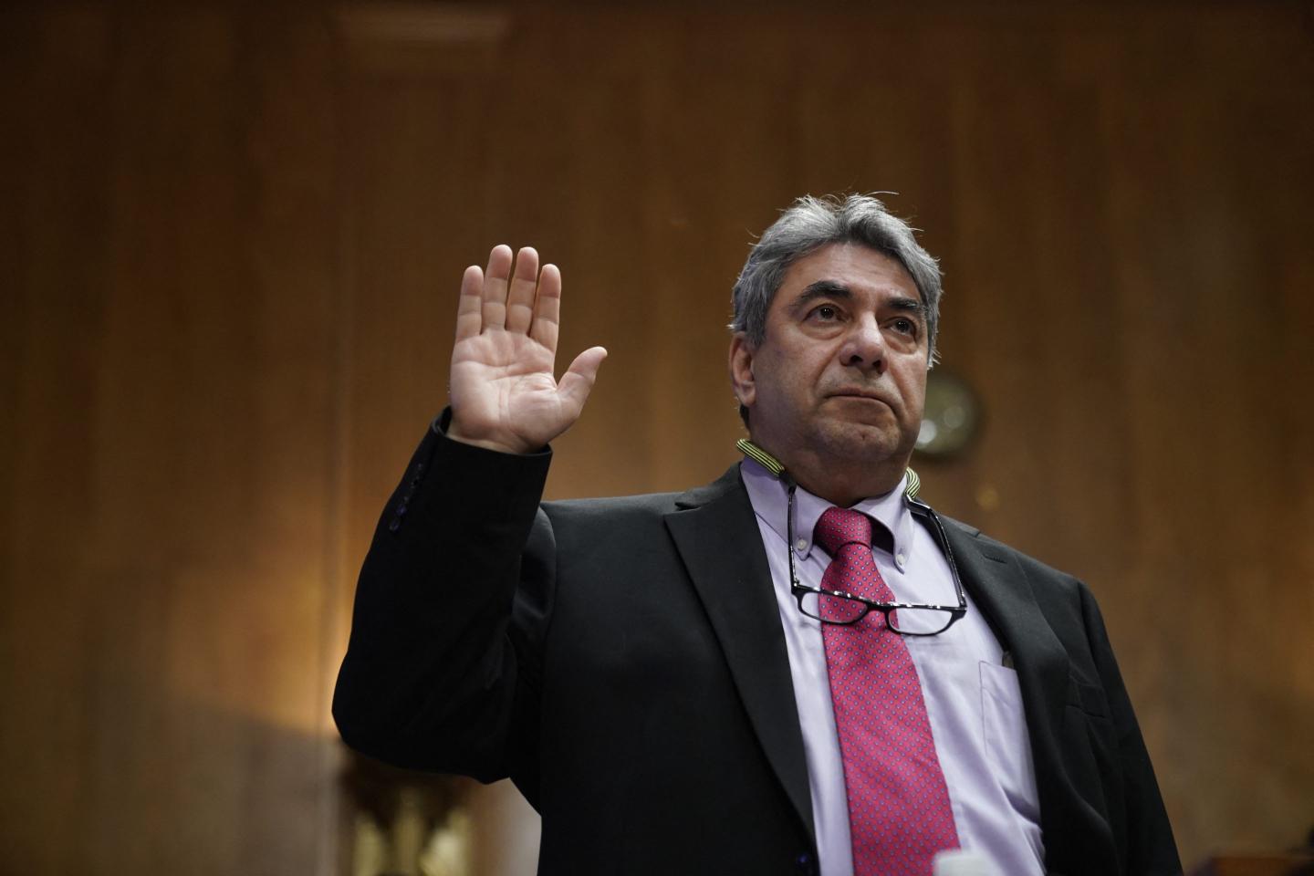 Sam Salehpour is wearing a suit and has his right had raised as he is sworn in during a Wednesday Senate hearing.