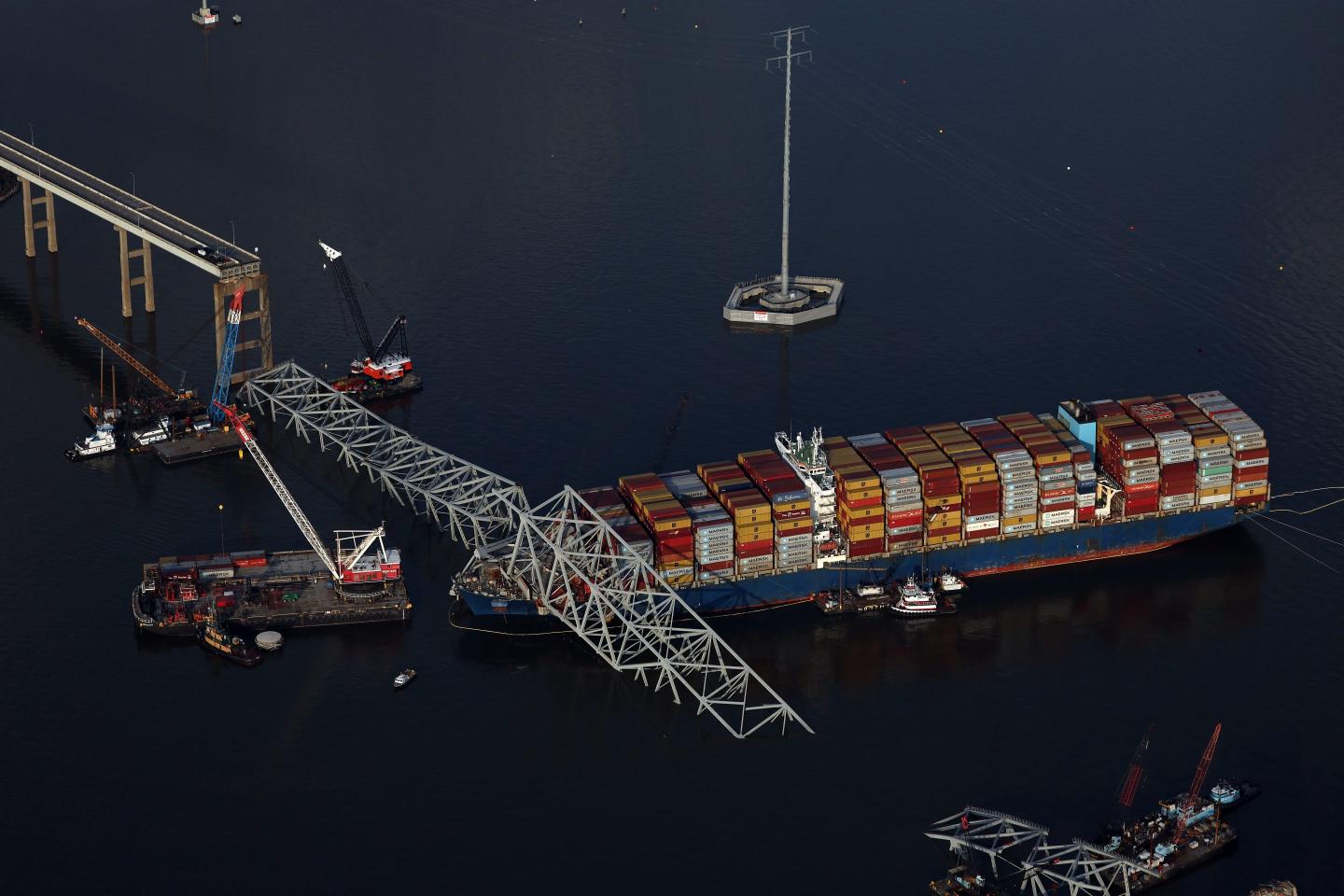 BALTIMORE, MARYLAND - APRIL 09: In an aerial view, salvage crews continue to remove wreckage from the cargo ship Dali after it stuck and collapsed the Francis Scott Key Bridge, April 09, 2024 in Baltimore, Maryland. The Unified Command has started removing containers from the Dali while also working to clear the channel to restore the flow of commerce to the Port of Baltimore. The bridge collapsed after being struck by the 984-foot cargo ship Dali at 1:30 AM on March 26. (Photo by Kevin Dietsch/Getty Images)