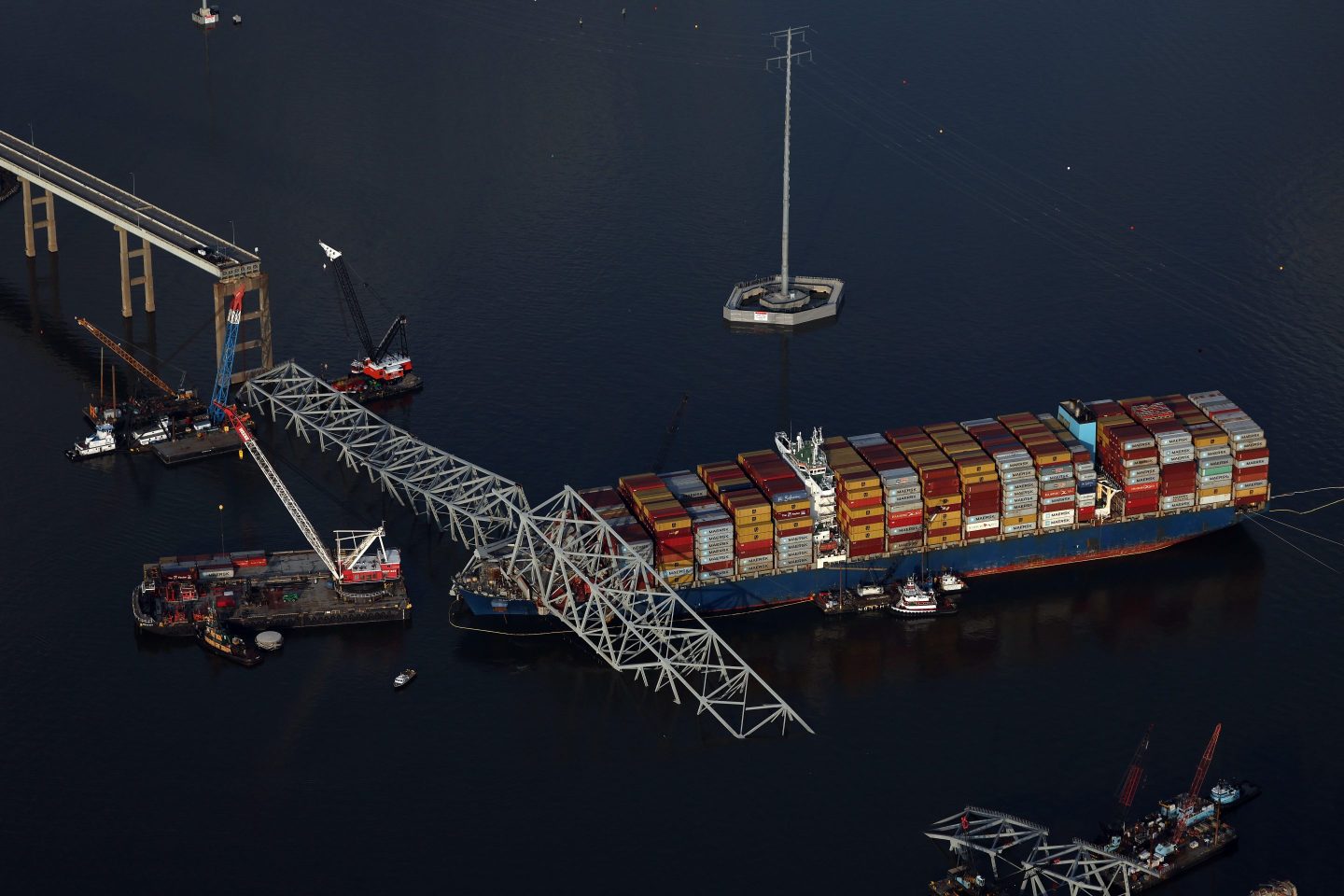 BALTIMORE, MARYLAND - APRIL 09: In an aerial view, salvage crews continue to remove wreckage from the cargo ship Dali after it stuck and collapsed the Francis Scott Key Bridge, April 09, 2024 in Baltimore, Maryland. The Unified Command has started removing containers from the Dali while also working to clear the channel to restore the flow of commerce to the Port of Baltimore. The bridge collapsed after being struck by the 984-foot cargo ship Dali at 1:30 AM on March 26. (Photo by Kevin Dietsch/Getty Images)