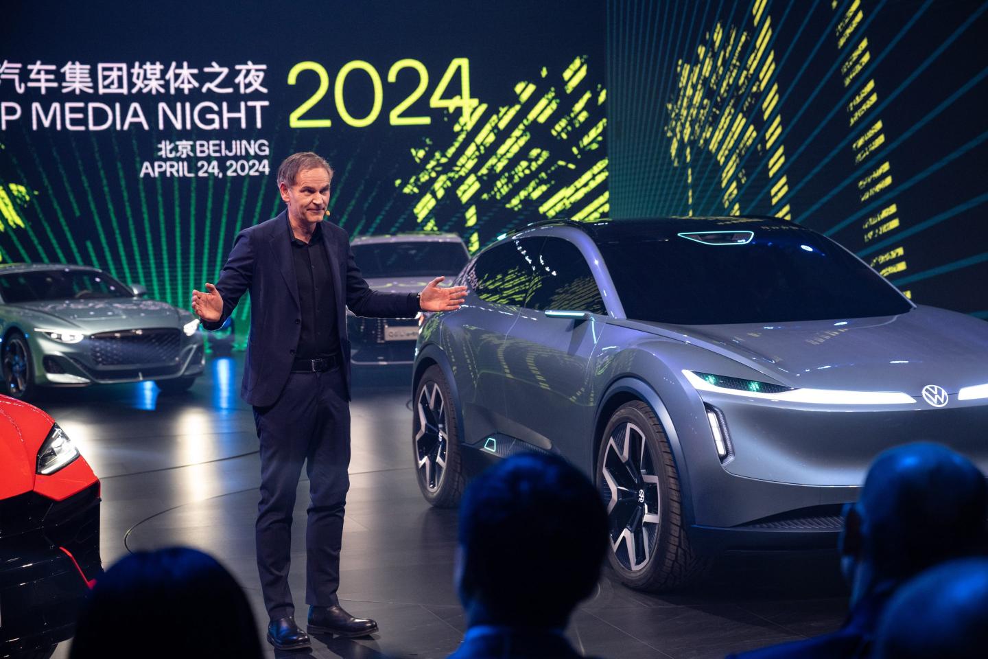 Oliver Blume, chief executive officer of Volkswagen AG, beside an ID.CODE concept car, right, at the Volkswagen AG media event in Beijing, China, on Wednesday, April 24, 2024. Volkswagen will start sales of a new electric-vehicle brand in China kitted out with gadgets like an in-car avatar to help win back young buyers it has lost to the likes of BYD Co.