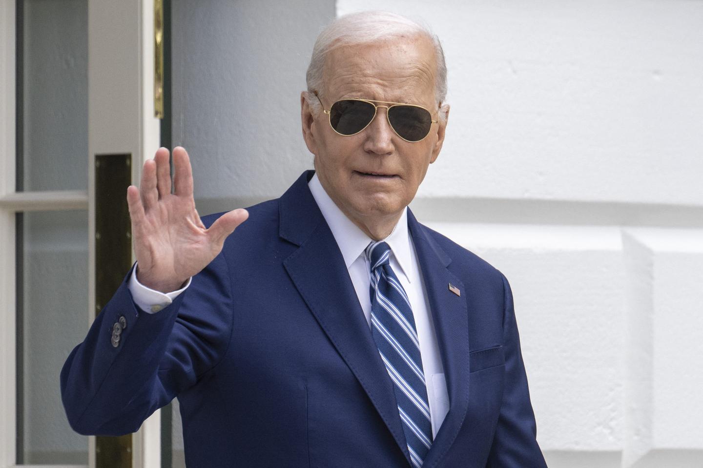 Joe Biden waves to reporters ahead of traveling to Syracuse, N.Y., for a funding announcement.