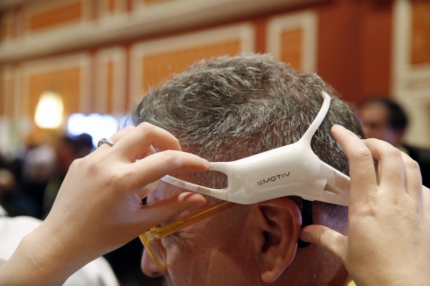An attendee tries on an Emotiv Inc. Insight wireless headset during the 2015 Consumer Electronics Show (CES) in Las Vegas, Nevada, U.S., on Tuesday, Jan. 6, 2015.