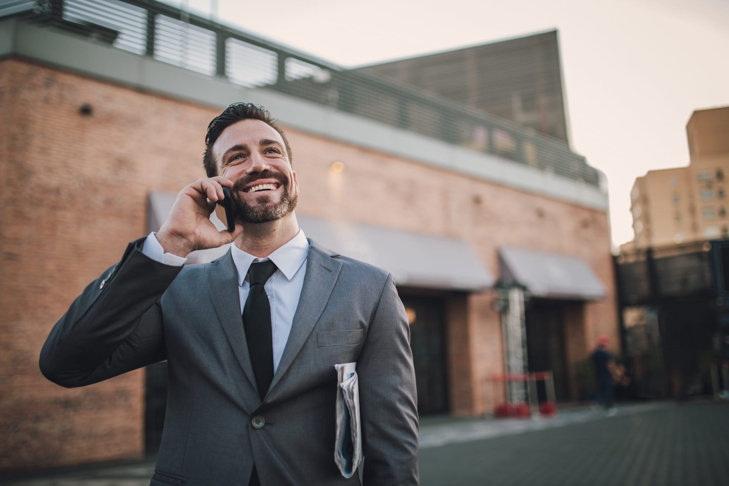 Young business man on street talking on the phone.