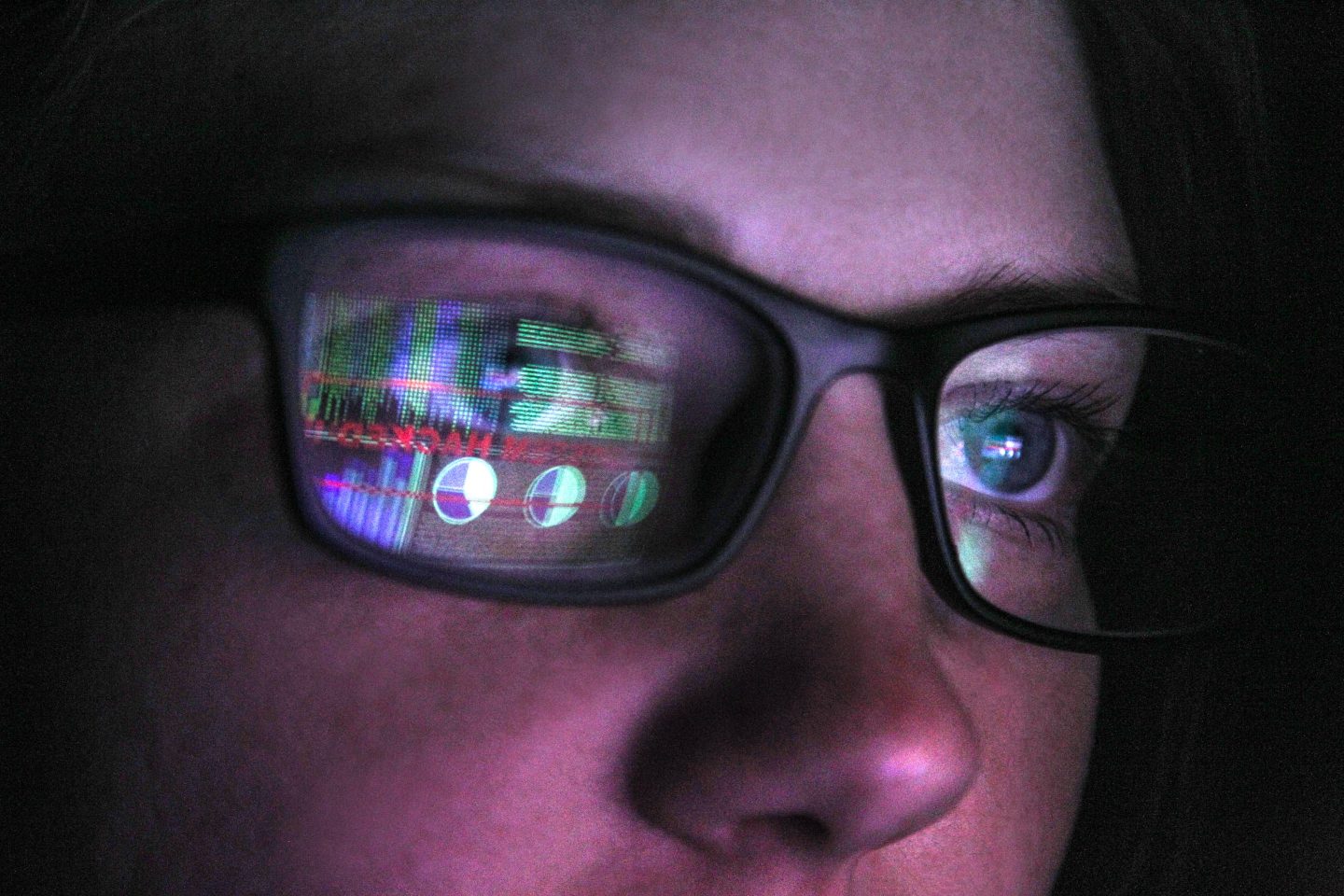 Image of someone looking at a computer screen in the darkness.