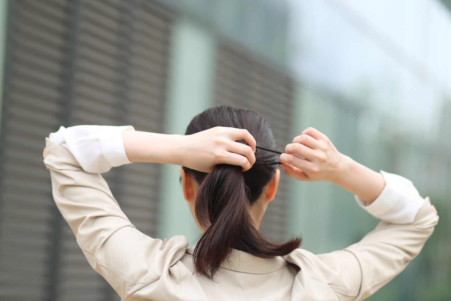 Woman tying back her hair.