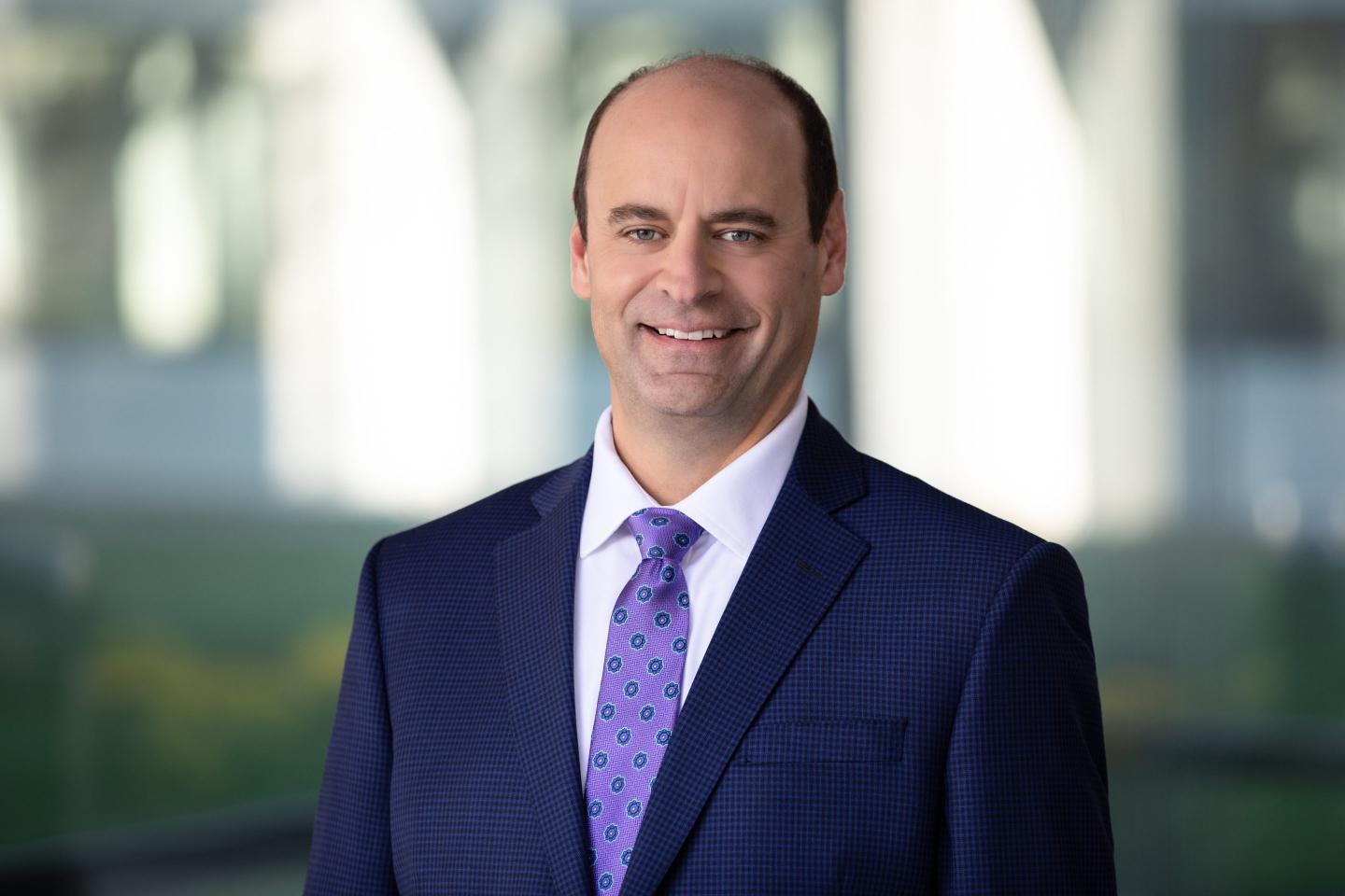 photo portrait of a middle aged man wearing a suit and tie