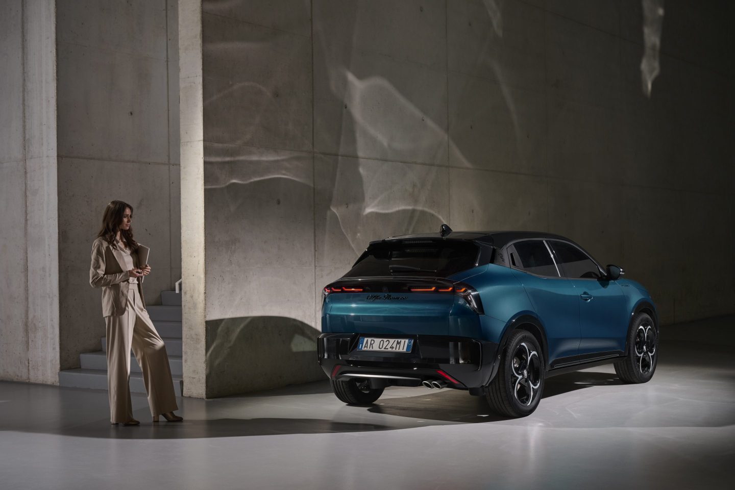 A woman stands beside the Alfa Romeo Junior.