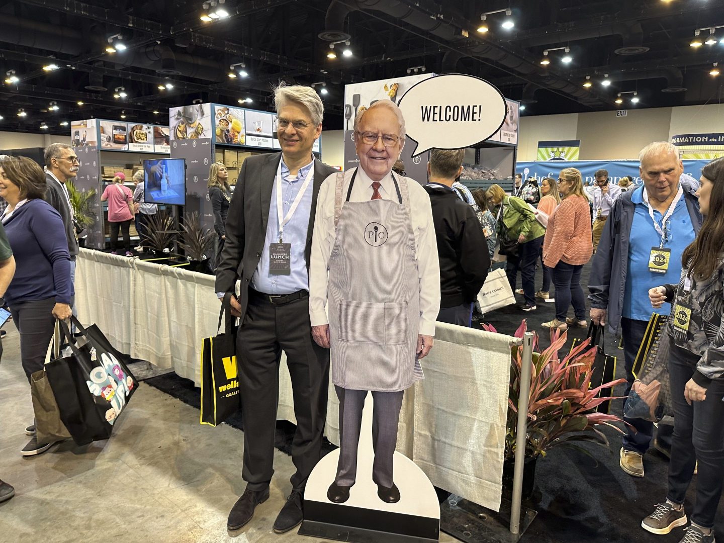 Berkshire Hathaway shareholders pose with a cutout poster of CEO Warren Buffett Friday, May 3, 2024, in Omaha, Neb., inside the exhibit hall in Omaha where Berkshire companies sell their products.