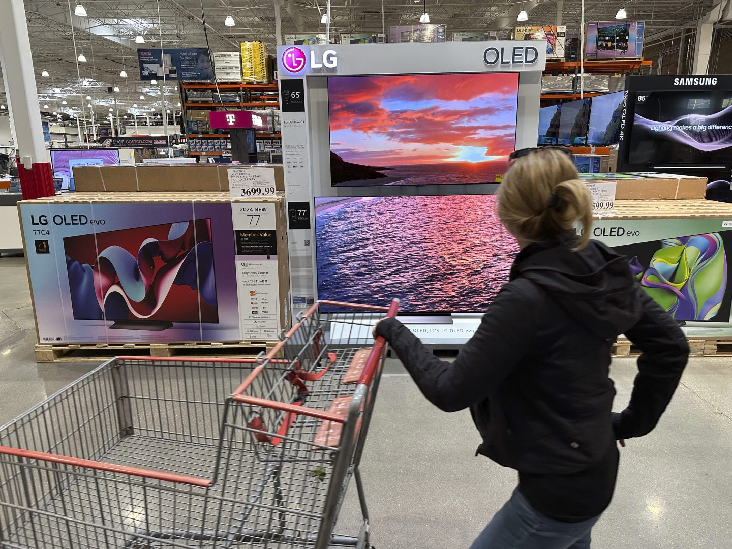 shopper passes a display of televisions