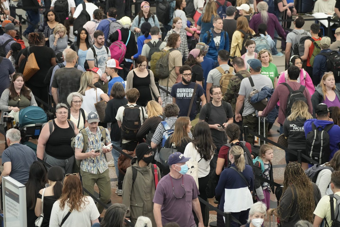 Travelers move through a security checkpoint in Denver International Airport ahead of the Memorial Day holiday on May 26, 2023.