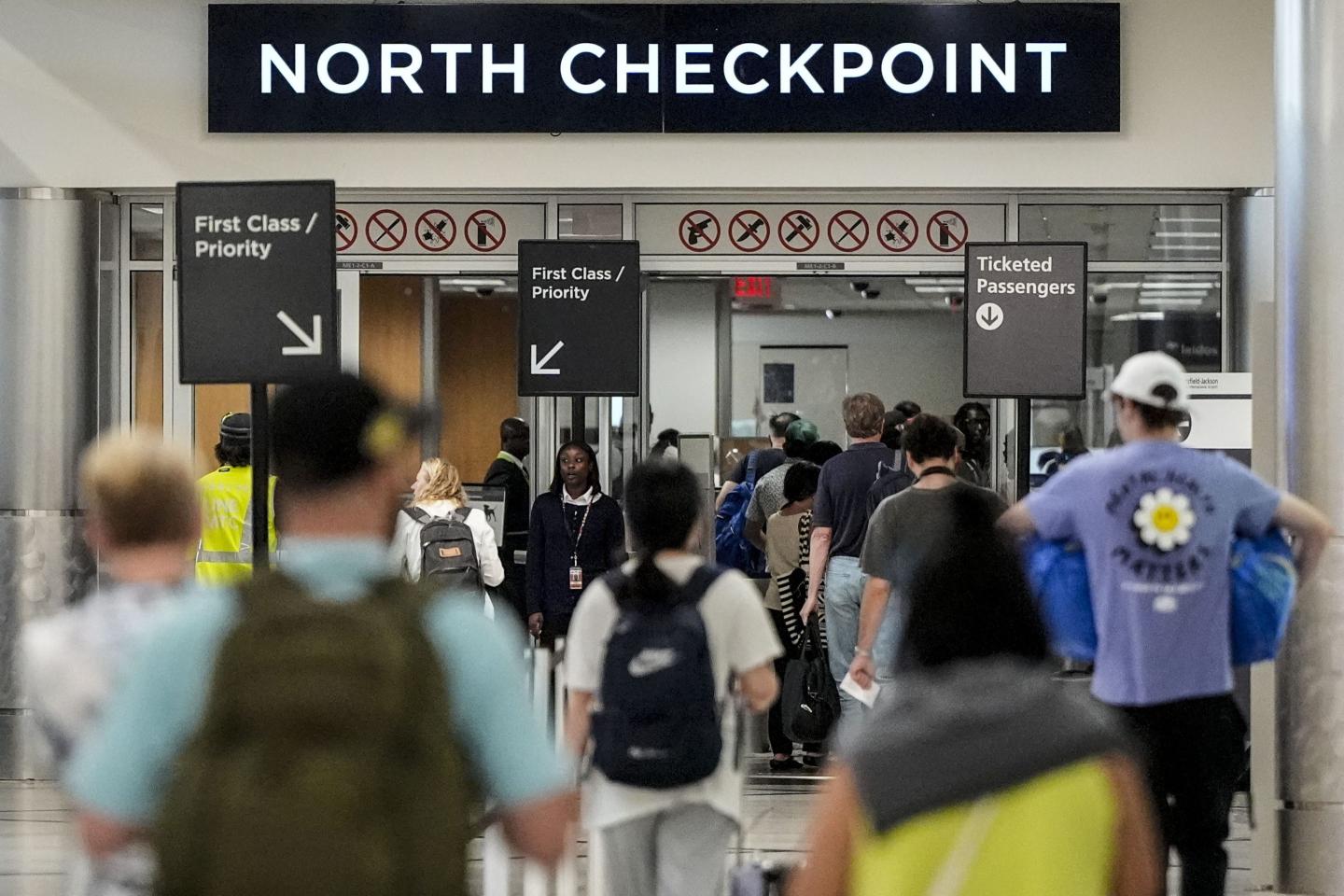 Travelers move through airport security